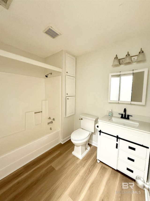 full bathroom with hardwood / wood-style floors, vanity, toilet, and shower / bathing tub combination