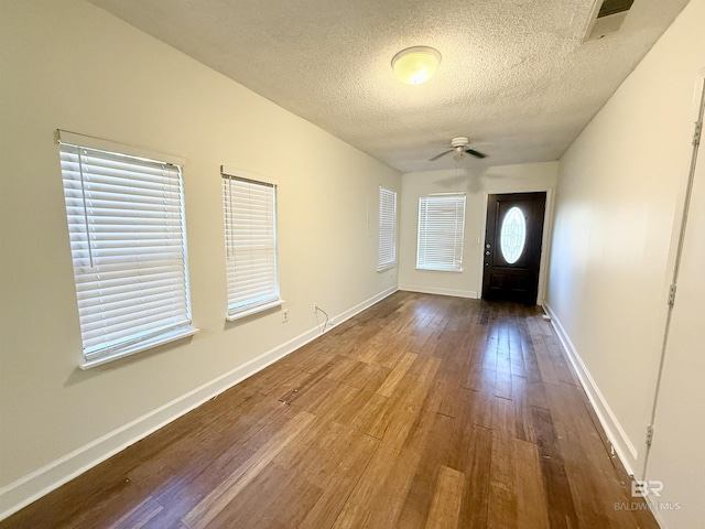 foyer entrance with ceiling fan, a healthy amount of sunlight, a textured ceiling, and hardwood / wood-style flooring