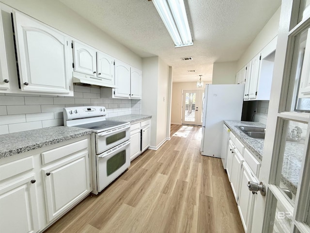 kitchen featuring white appliances, sink, a textured ceiling, light stone counters, and white cabinetry