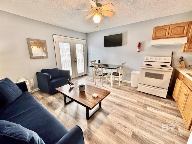 living area with baseboards, light wood-style flooring, ceiling fan, a textured ceiling, and french doors