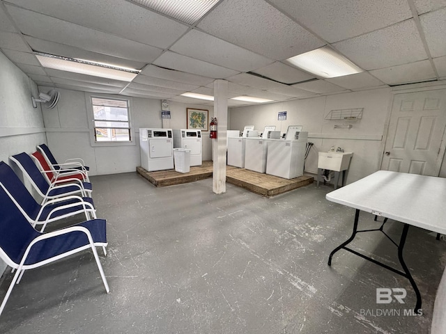 interior space featuring a sink, a drop ceiling, and washer and dryer