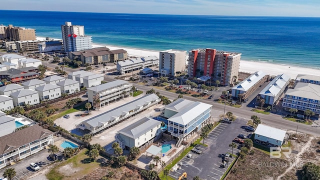 birds eye view of property with a water view, a view of city, and a beach view