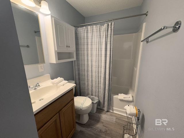 full bathroom featuring hardwood / wood-style floors, shower / bath combination with curtain, vanity, toilet, and a textured ceiling