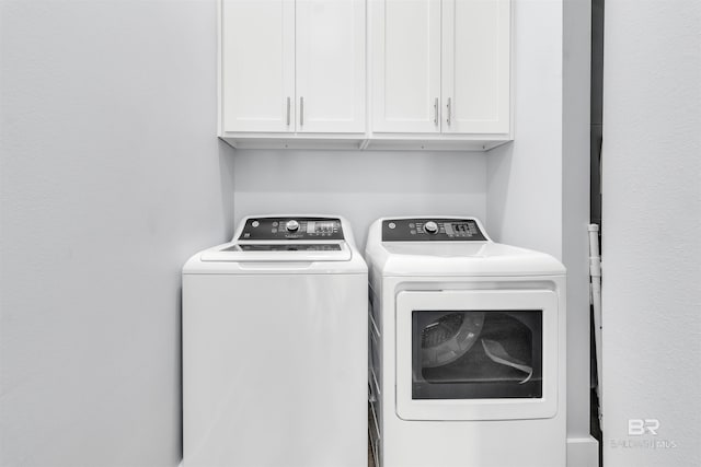 washroom featuring cabinet space and independent washer and dryer