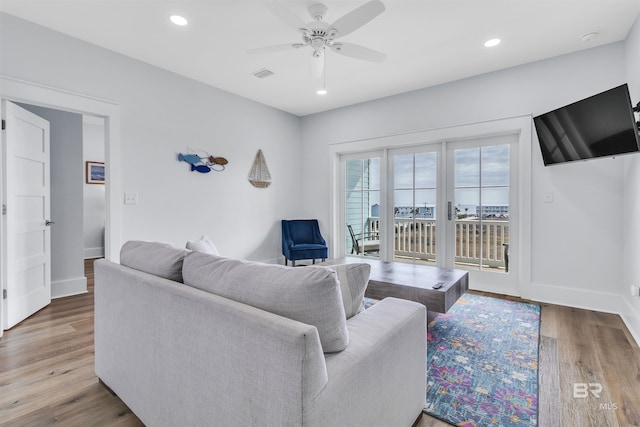 living area with recessed lighting, visible vents, baseboards, and wood finished floors