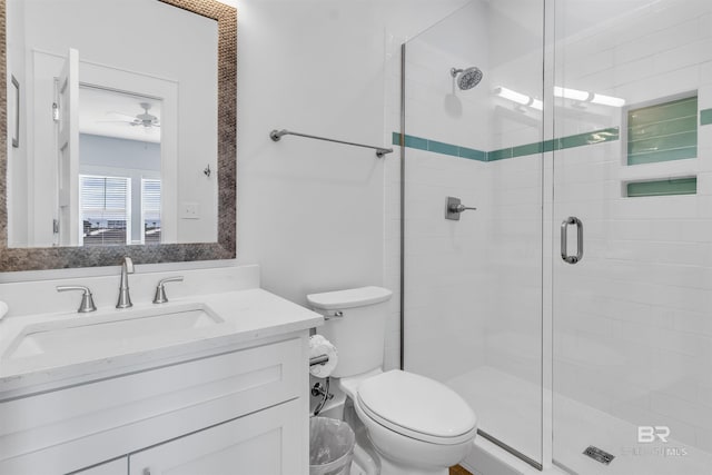 full bathroom featuring ceiling fan, a stall shower, vanity, and toilet
