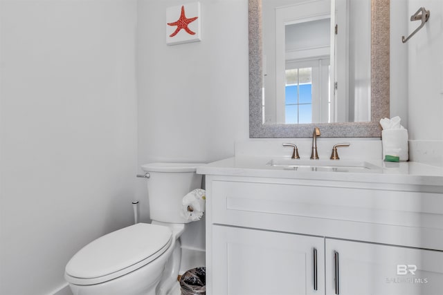 half bathroom featuring vanity and toilet