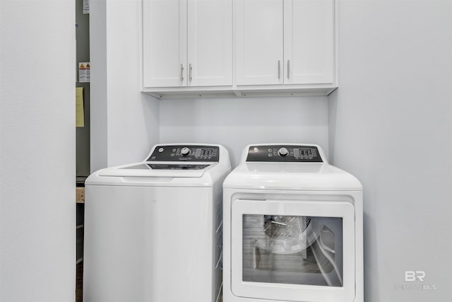 laundry room featuring independent washer and dryer and cabinet space