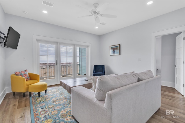 living area featuring recessed lighting, visible vents, and wood finished floors