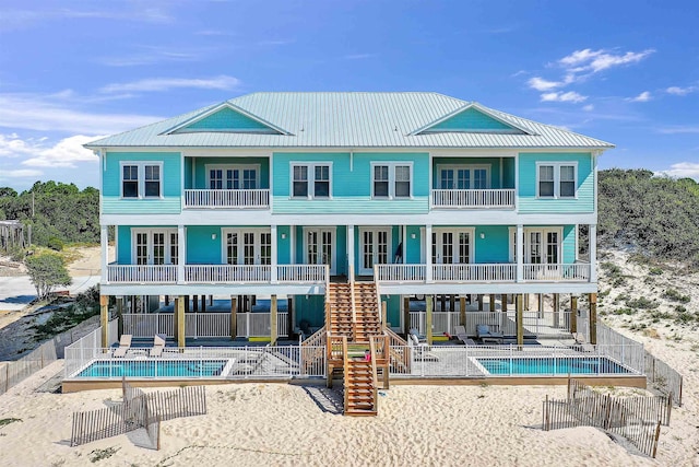 back of property with french doors, a patio area, a balcony, and stairs