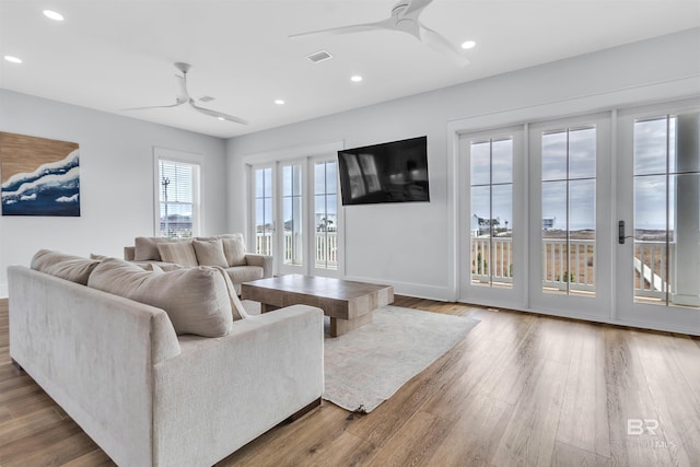 living room with a ceiling fan, recessed lighting, visible vents, and wood finished floors