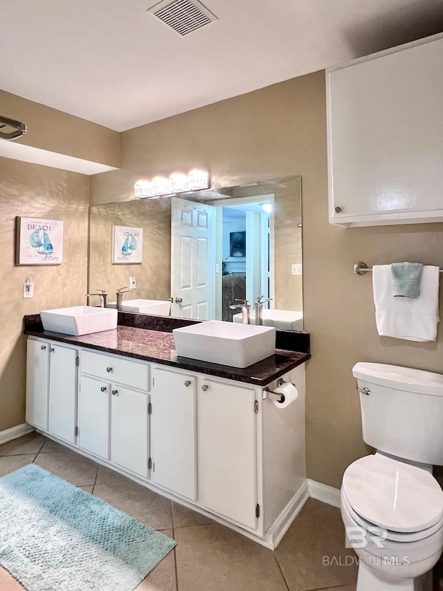 bathroom with double vanity, toilet, and tile patterned flooring