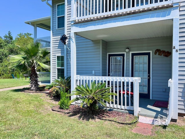 doorway to property featuring a yard and a balcony