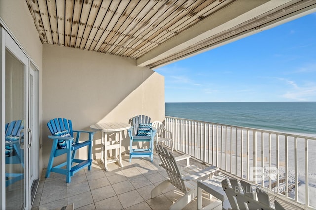 balcony featuring a water view and a beach view