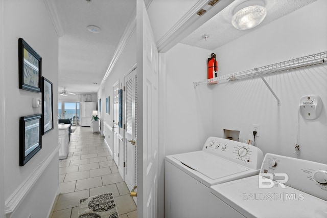 laundry room featuring washing machine and dryer, ceiling fan, light tile flooring, a textured ceiling, and crown molding