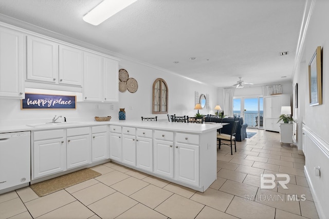 kitchen with ceiling fan, light tile floors, white dishwasher, white cabinetry, and crown molding