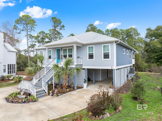 raised beach house featuring a carport and covered porch