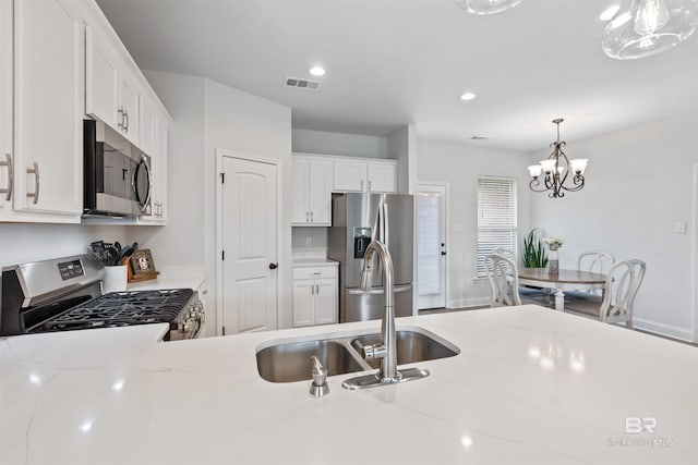 kitchen with a sink, a notable chandelier, white cabinetry, visible vents, and appliances with stainless steel finishes