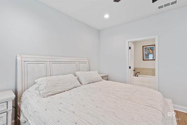 bedroom featuring recessed lighting, baseboards, ensuite bathroom, visible vents, and wood finished floors
