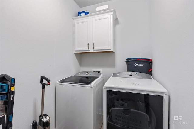 laundry room with separate washer and dryer and cabinet space