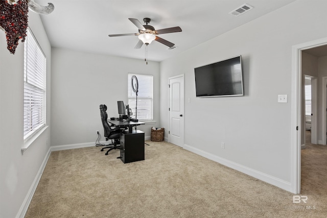 office space with carpet floors, a ceiling fan, and visible vents