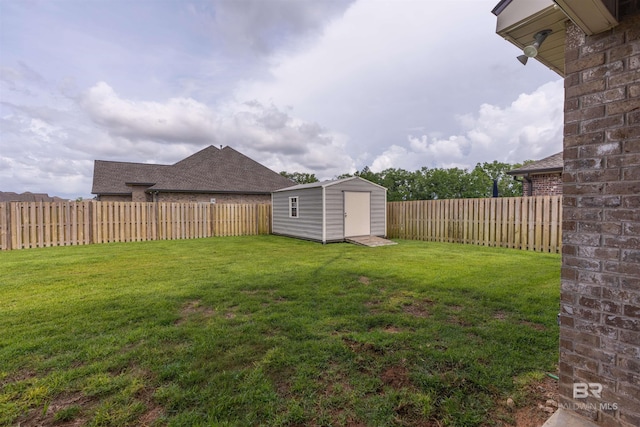 view of yard with an outdoor structure, a fenced backyard, and a storage unit
