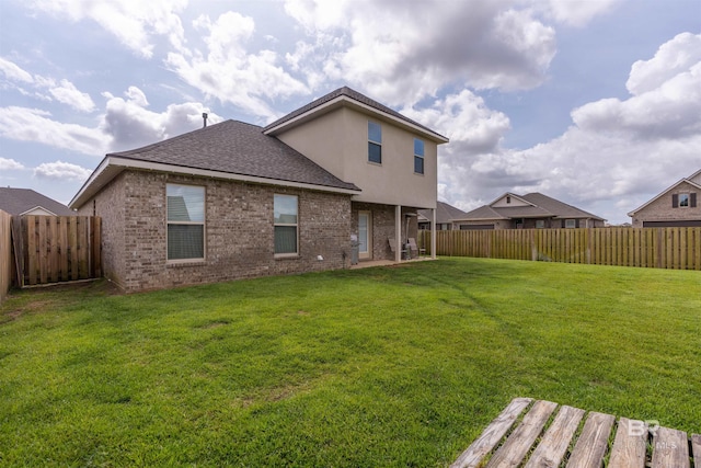 back of property with a yard and a fenced backyard