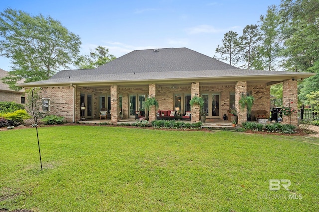 rear view of house featuring a patio, a yard, and french doors