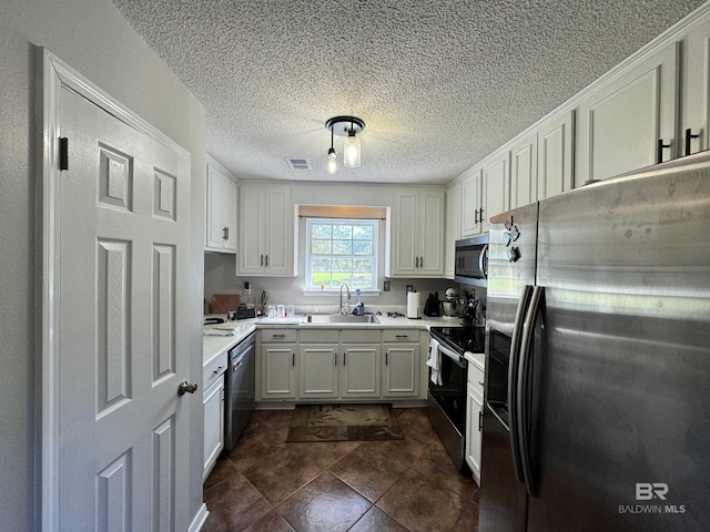 14313 Hemley Rd, Coden, AL 36523 - kitchen with appliances with stainless steel finishes, a sink, light countertops, white cabinets, and a textured ceiling