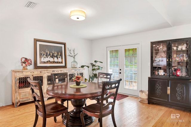 dining area with french doors and light hardwood / wood-style flooring