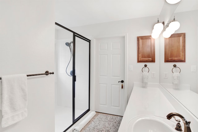 bathroom with a shower with shower door, tile floors, and sink