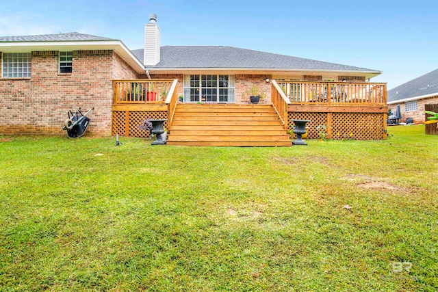 rear view of house featuring a wooden deck and a lawn