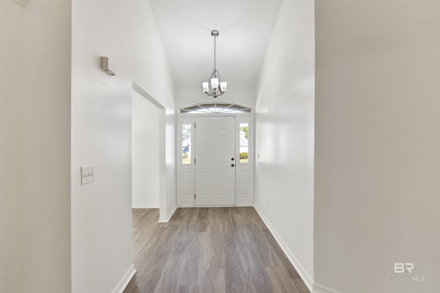 entryway featuring wood-type flooring and an inviting chandelier