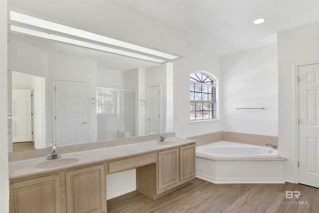 bathroom with independent shower and bath, vanity, and wood-type flooring