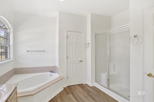 bathroom featuring vanity, plus walk in shower, and hardwood / wood-style flooring