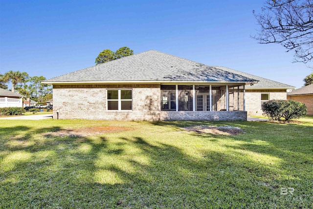 rear view of property featuring a sunroom and a yard