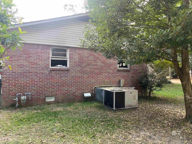 view of property exterior with a yard and central AC unit