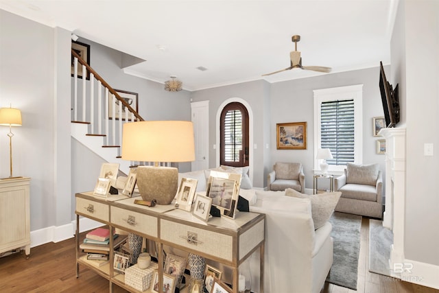 living room featuring wood-type flooring, ceiling fan, and crown molding