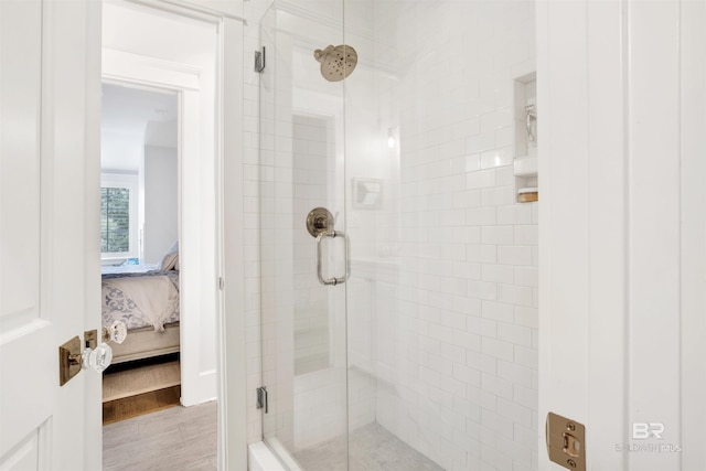 bathroom with an enclosed shower and hardwood / wood-style flooring