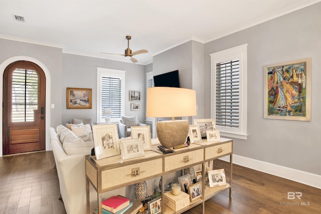 living room featuring crown molding, dark wood-type flooring, and ceiling fan