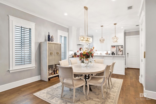 dining room with ornamental molding, dark hardwood / wood-style floors, and a notable chandelier