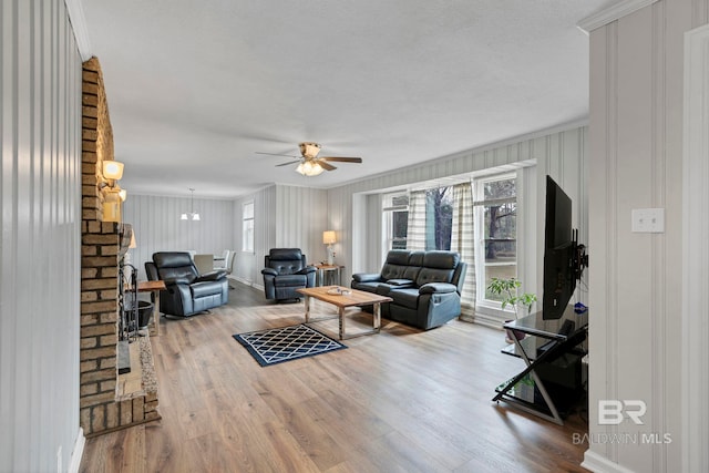 living room with hardwood / wood-style flooring, crown molding, a textured ceiling, and ceiling fan