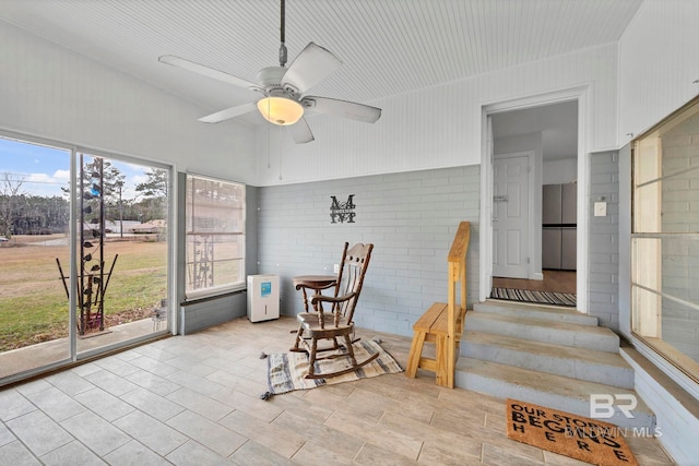 sunroom / solarium featuring ceiling fan