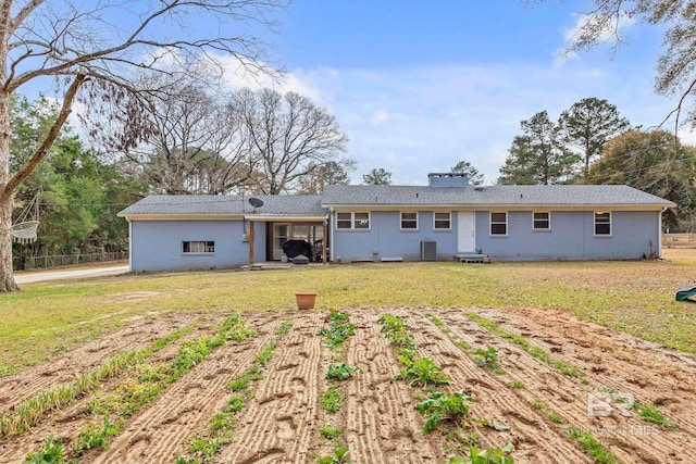 rear view of property with cooling unit and a yard