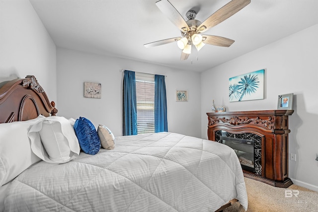 bedroom featuring ceiling fan, light carpet, and a fireplace