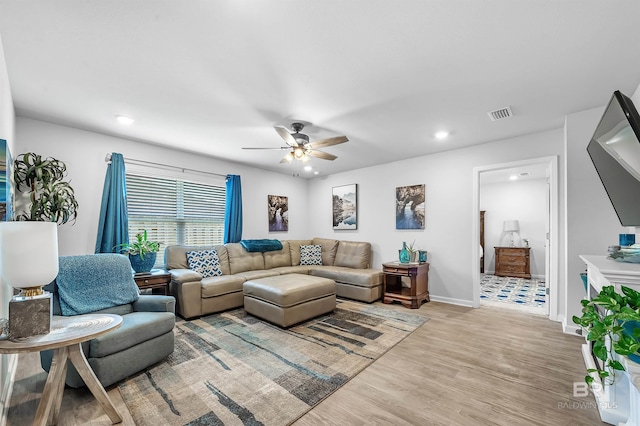 living room featuring ceiling fan and light hardwood / wood-style floors