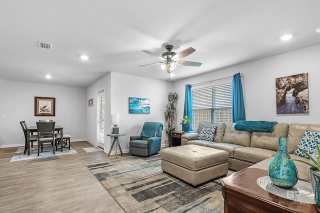 living room featuring ceiling fan and light hardwood / wood-style floors