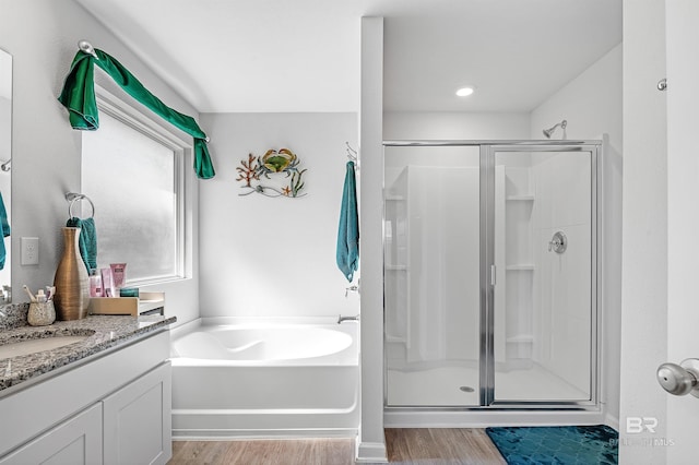 bathroom featuring hardwood / wood-style flooring, separate shower and tub, and vanity