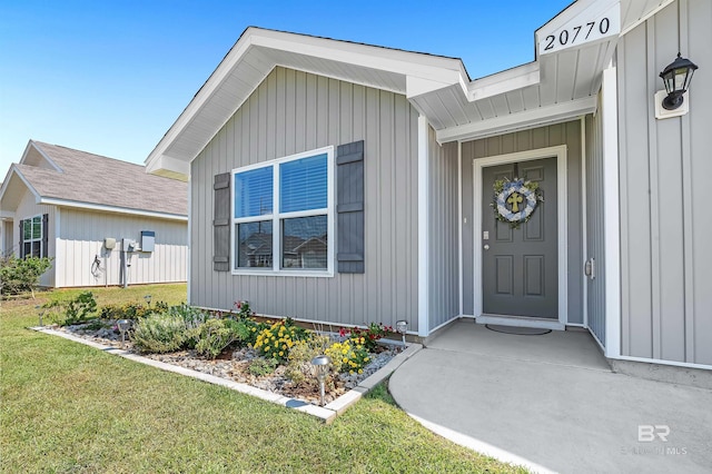 view of exterior entry with a lawn