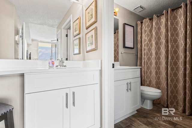 527 Beach Club Trl Unit C908, Gulf Shores, AL 36542 - full bathroom with visible vents, vanity, wood finished floors, toilet, and a textured ceiling